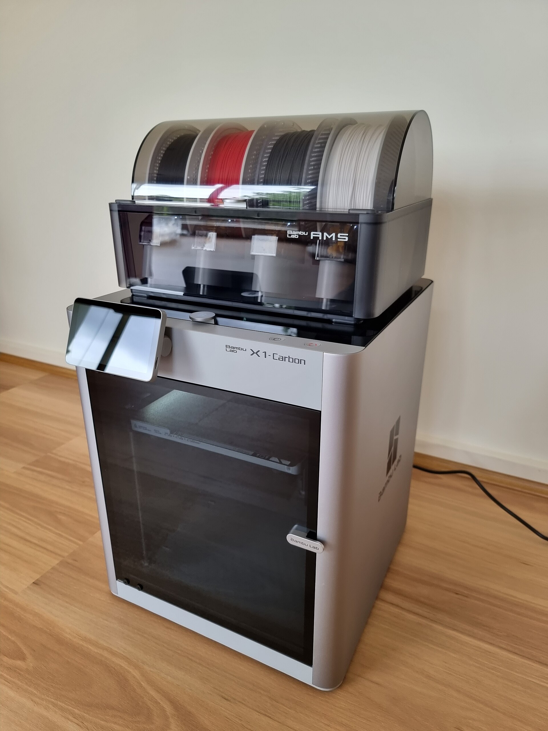 Reference photograph of a Bambu Lab X1 Carbon with an AMS unit, the printer model used in HOLK TECH laboratory tests
